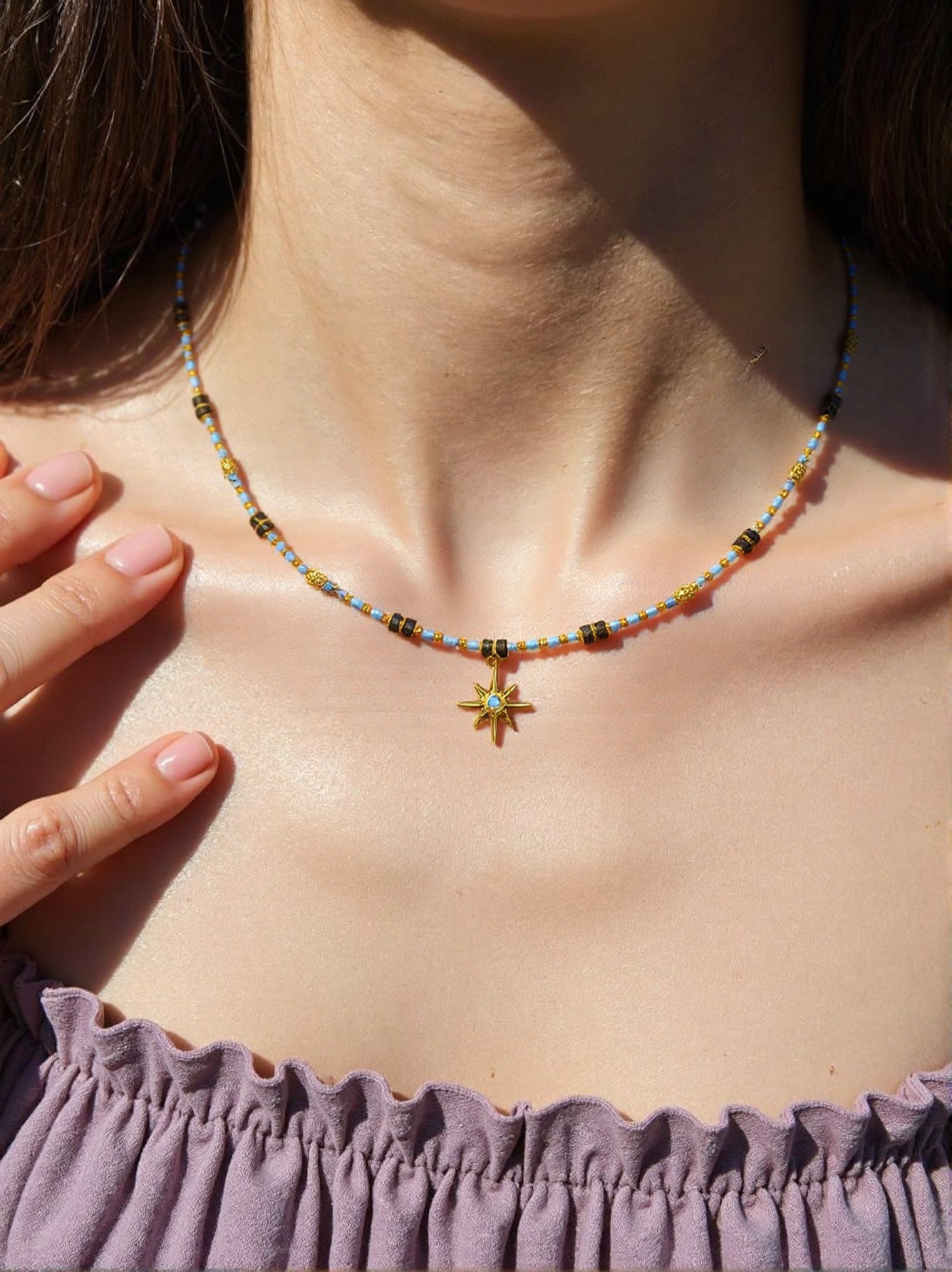 Colorful beaded necklace with six-pointed gold star pendant and crystal center on woman’s neck