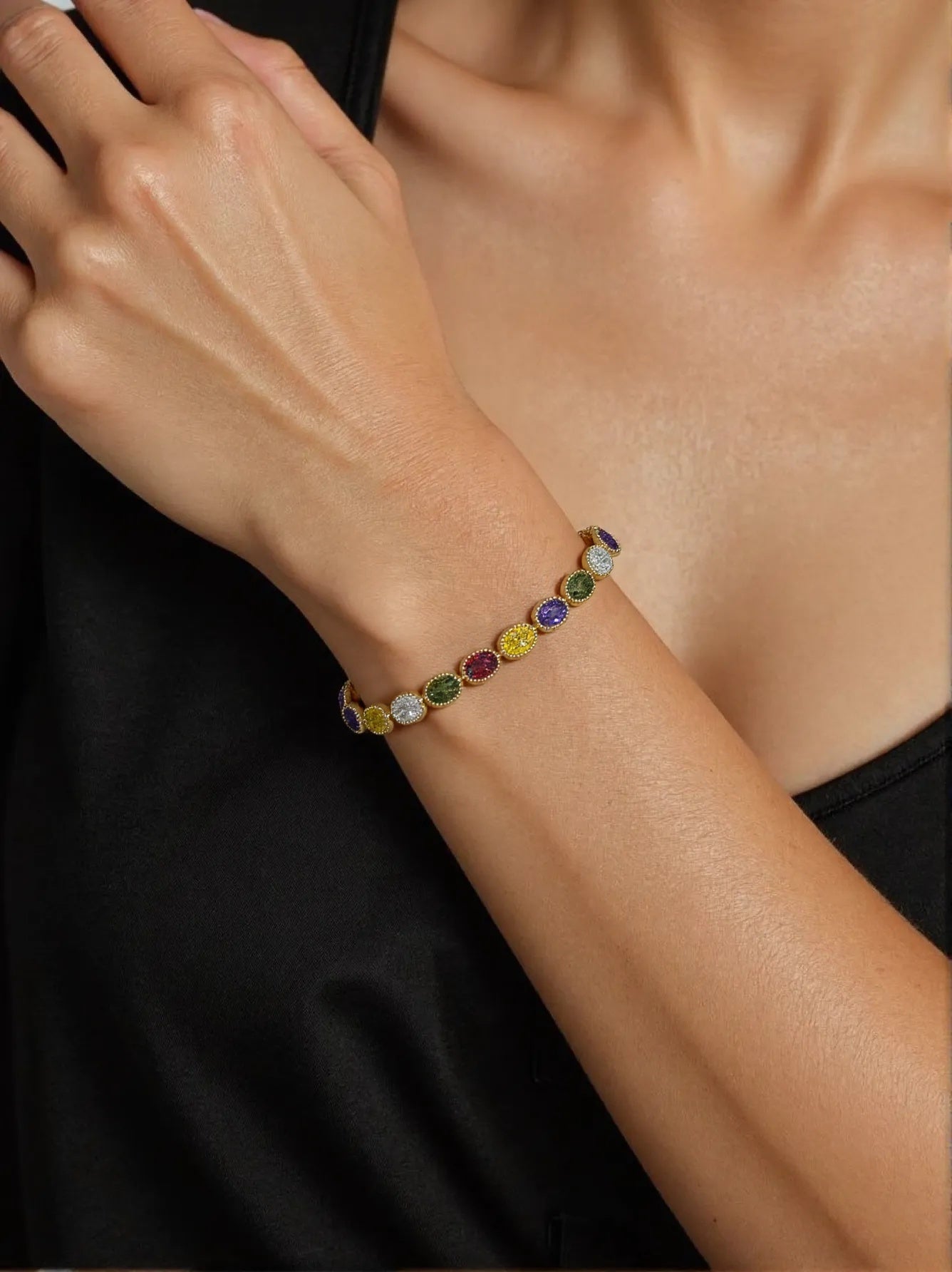 Gold bracelet with colorful oval-cut gemstones on woman's wrist – EVE Jewelry