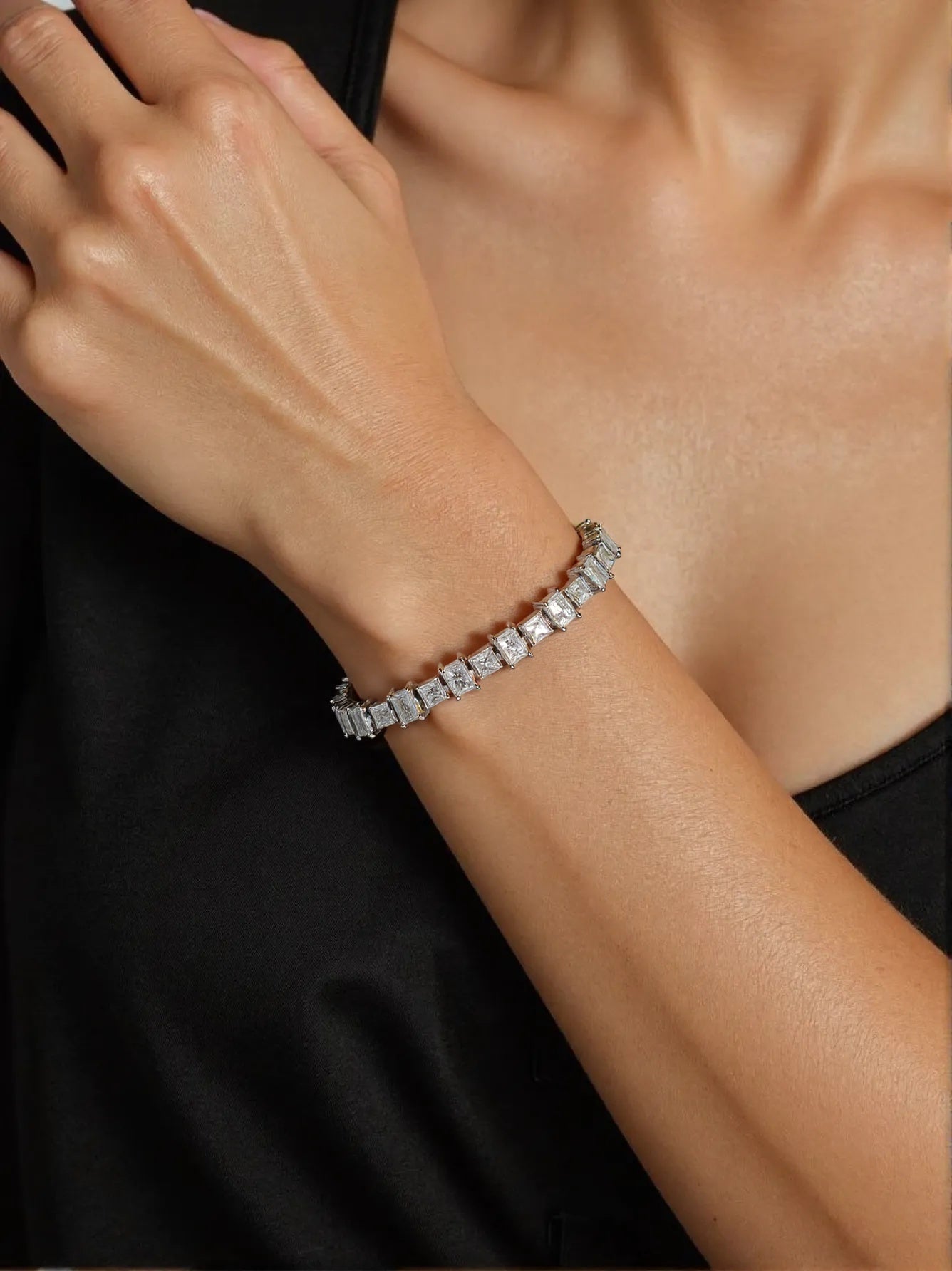 Elegant silver bracelet with square-cut diamonds on woman’s wrist