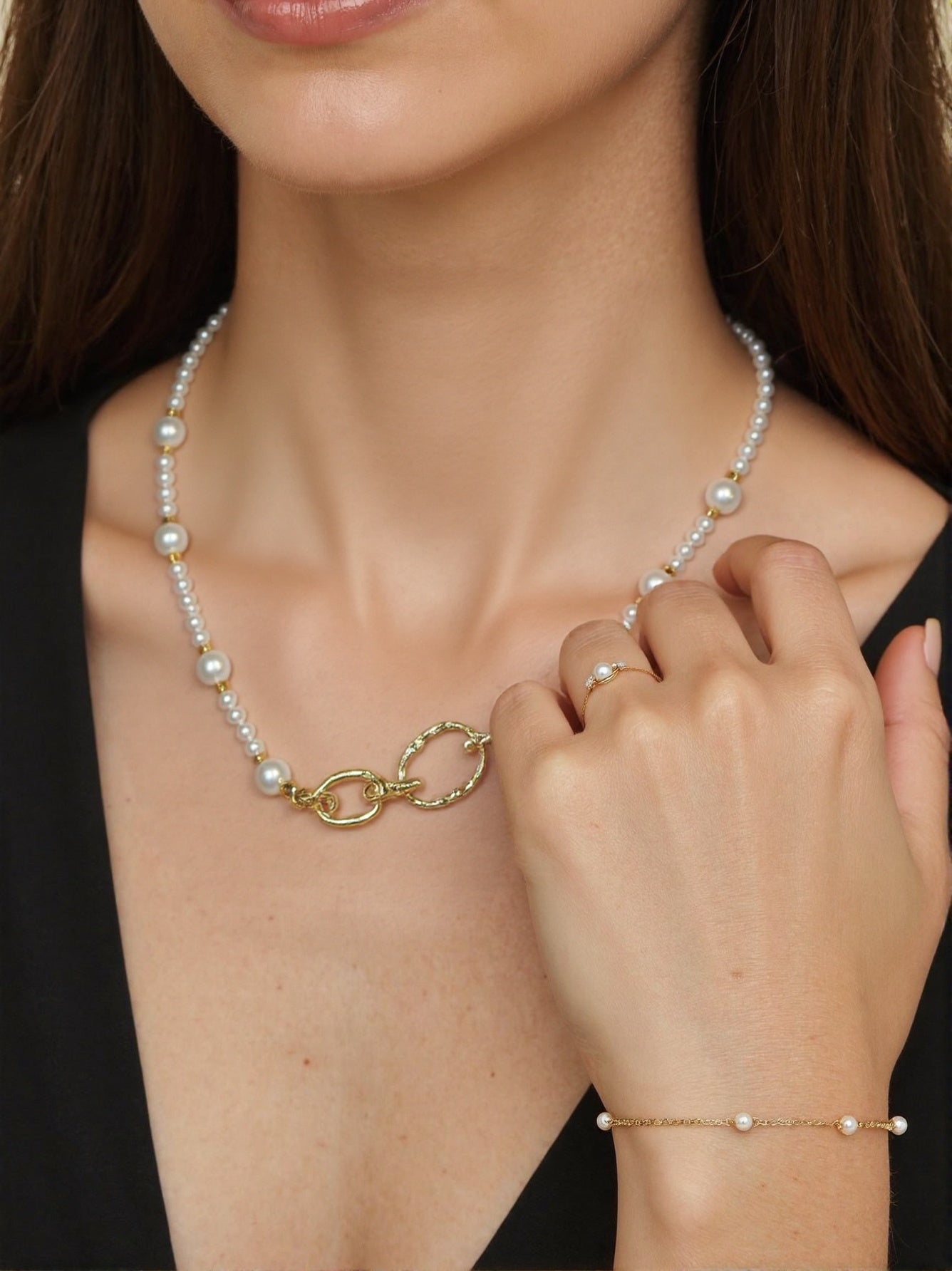 Pearl necklace with gold toggle clasp, matching pearl ring and bracelet on woman